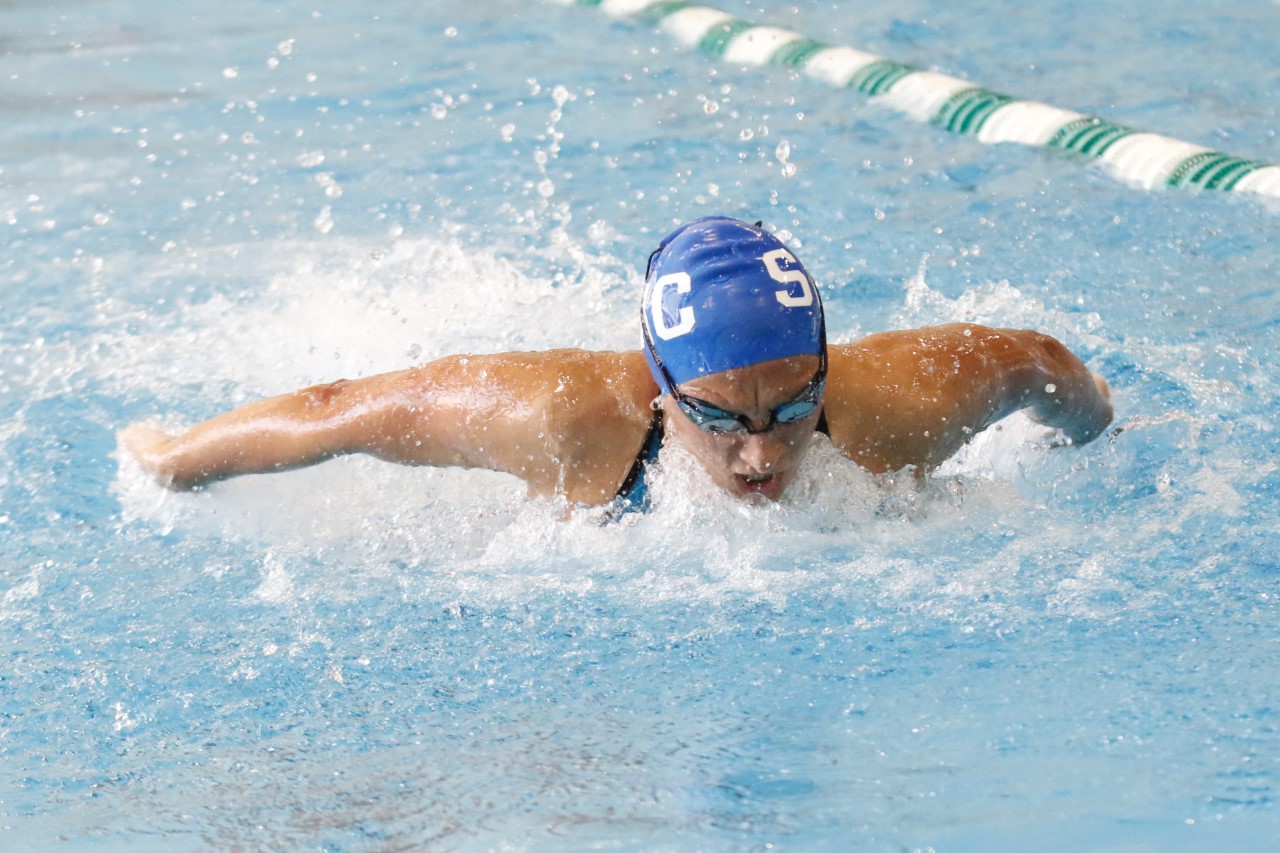 SMC Women's Swimmer Swimming with blue swim cap.
