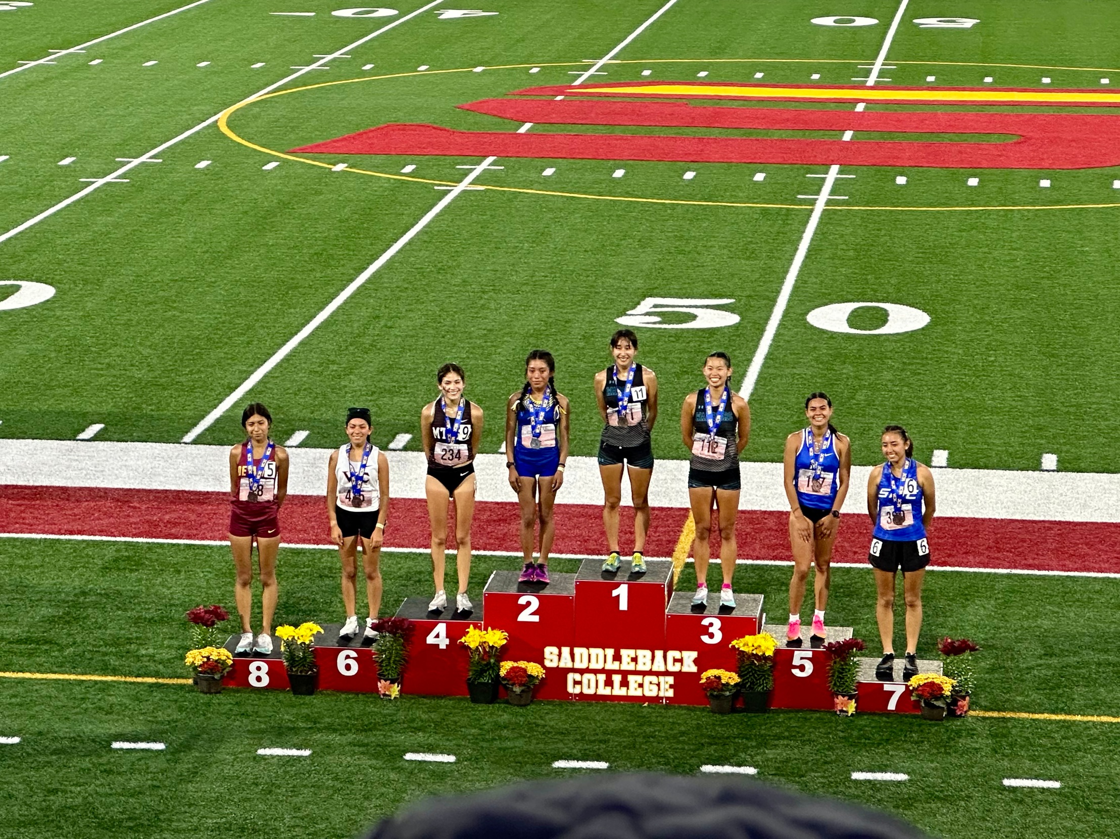Track Athletes standing on the winner's podium.